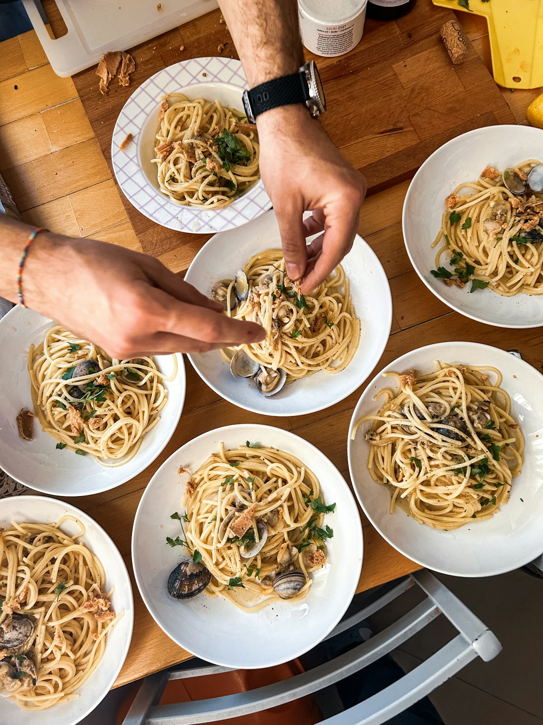Mani che impiattano spaghetti alle vongole